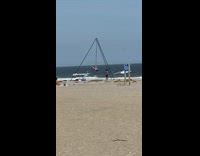 Lady spins from rope at the beach for dance 