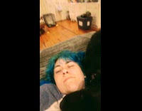 Dog cuddles with woman laying on bed