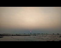Time lapse sunset on beach with boats