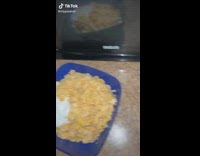 Guy pours chunky milk into blue bowl of cereal
