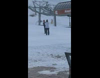 Blue overalls girl poses on snow mountain 
