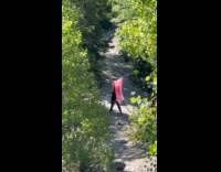 Woman waves large fan for forest video
