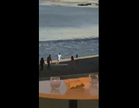 Man tiktok dance while lights flicker on the beach