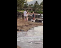 Woman in a blue dress and white boots at the beach