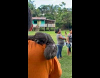 Boy orange shirt with baby sloth on shoulder
