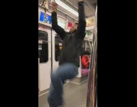 Guy tries to do back flip off of subway handle bars falls to ground