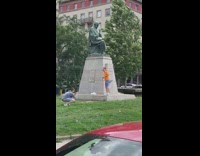 Man orange raise feet near statue for photoshoot illusion