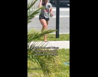 Small duck following a woman outside in front lawn