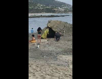 Two girls pose by grey rock cave 
