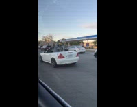 Shopping cart on white convertible on road