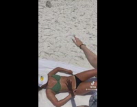 Friend has hand over girl tanning at beach 