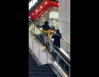 Two girls yellow coat cleavage upward escalator