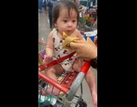 Baby pulls parent hand for more bite 