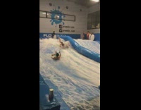 Two guys fall in blue wave pool 