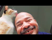 Cat licks the head of bald man