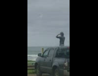 Collab Kook Of The Day - Guy Does Weird Arm Warmup While Standing Out Sunroof of Truck in Front Beach