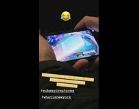 Man watches live stream cock fight on his phone on subway train