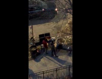 Two guys fire up grill on sidewalk