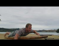 Grey Shirt Surfboard Practices Standup on Iron Pole Trainer