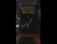 Girl kicks basketball into guys chest after he jumps on trampoline and dunks it into hoop