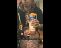 Guy drinks Dunkin Donuts coffee creamer bottle on subway train