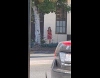 Woman red dress video shoot outside building