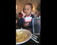 girl in white shirt sucking on lemon and making funny face 