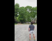 Guy throws and catches blue brown boomerang on street