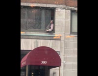 Woman smokes on top of building window