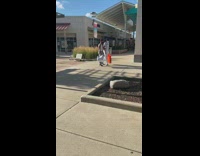 Two guys walk across outdoor shopping plaza 