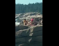 Woman in pink shorts did a handstand on the beach rocks