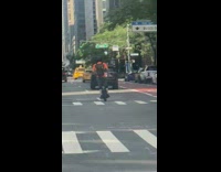 Orange shirt guy rides onewheel down street 