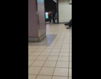 man in black waving arms around in subway station
