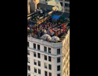 Crowd dress as Santa parties at rooftop