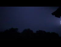 Slow motion lightning strike over trees night