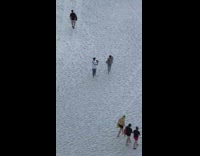 Girl jacket walk on sand camera flash