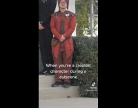 Guy dressed as red joker jester at wedding friends in suits