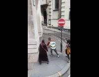 Woman in black top dances with friends on the sidewalk