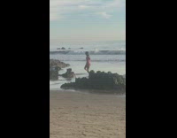 Woman in red bikini tiktok dance at the beach