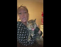 Woman holds cat who sings WAP