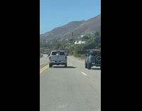 Guy behind pickup truck film moving jeep