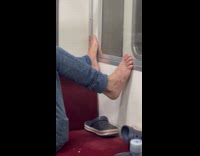 Man lay on train bare feet on wall