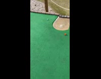 Mini golf ball goes over hill and then goes into water