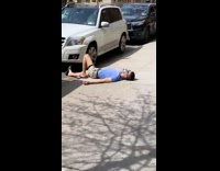 Guy Sunbathes on Sidewalk Laying Down 