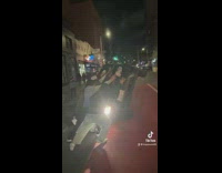 Group of people help flip black SUV car back 