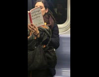 Woman reads book called siblings without rivalry on subway train