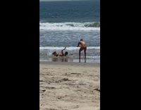 Two guys beach speedo rolling