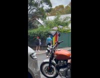 Woman lean pose Pride flag on sidewalk