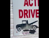 Tiny woman sits on parking lot sign