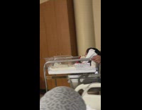 Man Shows Infant around in Hospital Baby Cart